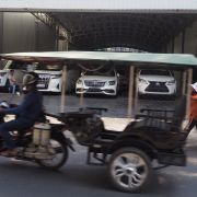 Phnompenh, někdo v rikše, někdo pěšky a na někoho čeká Lexus