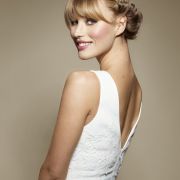 Vlasy si rozdělte na pěšinku na straně. V přední části ofiny pak vezměte dva prameny, obtočte je kolem hlavy, následně přibírejte další pramínky po celém obvodu, a splítejte až dokud se nedostanete až k temeni. Tam pak vlasy připíchněte sponkou, aby se vám nerozpletly. Stejný proces zopakujte i z druhé strany. Kadeře už jen stáhněte do ohonu. Zatočte kolem gumičky a připíchněte sponkami. A nebo použijte opět drdolovou vycpávku a vlasy do ní zarolujte a následně je upevněte pinetkami.