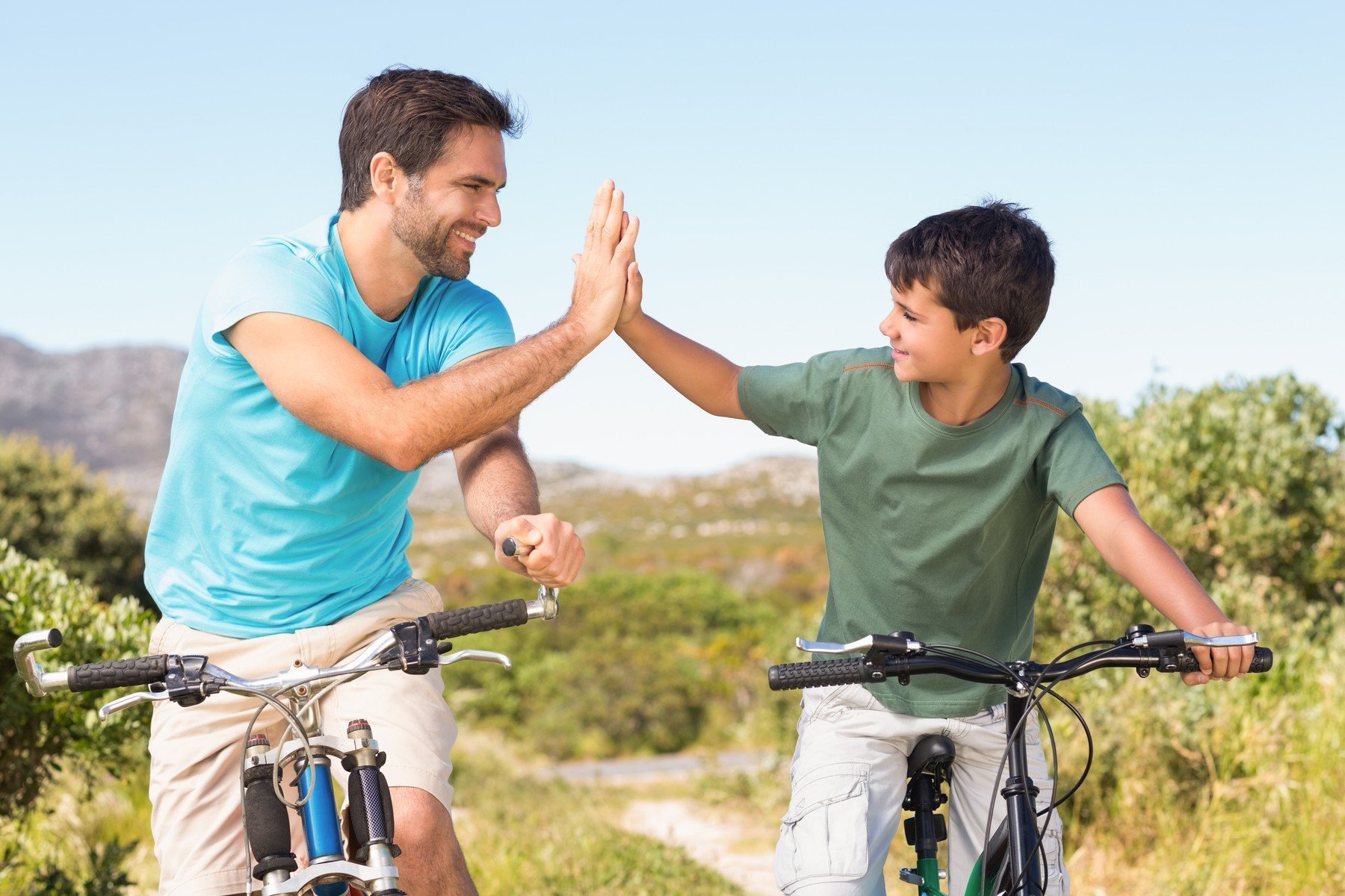 father son bikes highfive